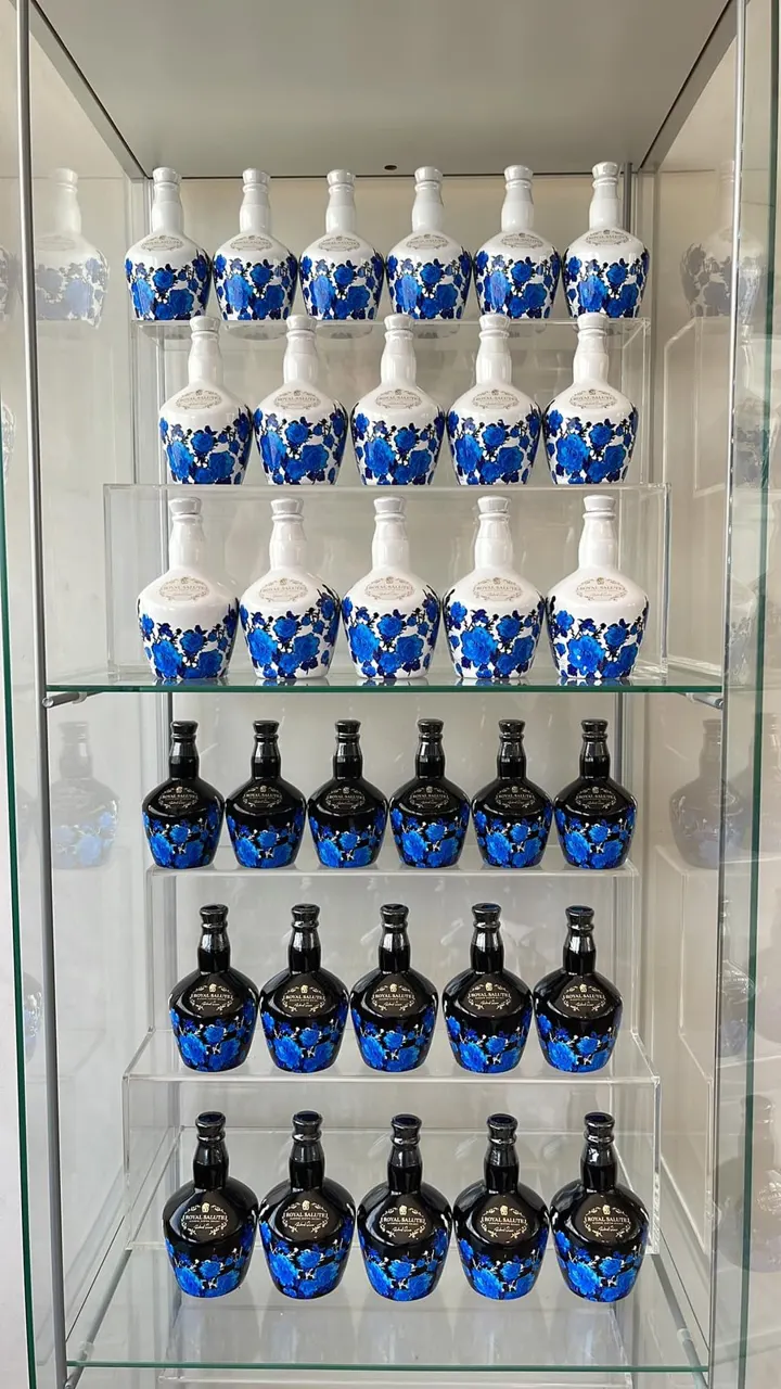 Cabinet with rows of Richard Quinn White Roses and Black Roses Royal Salute miniatures