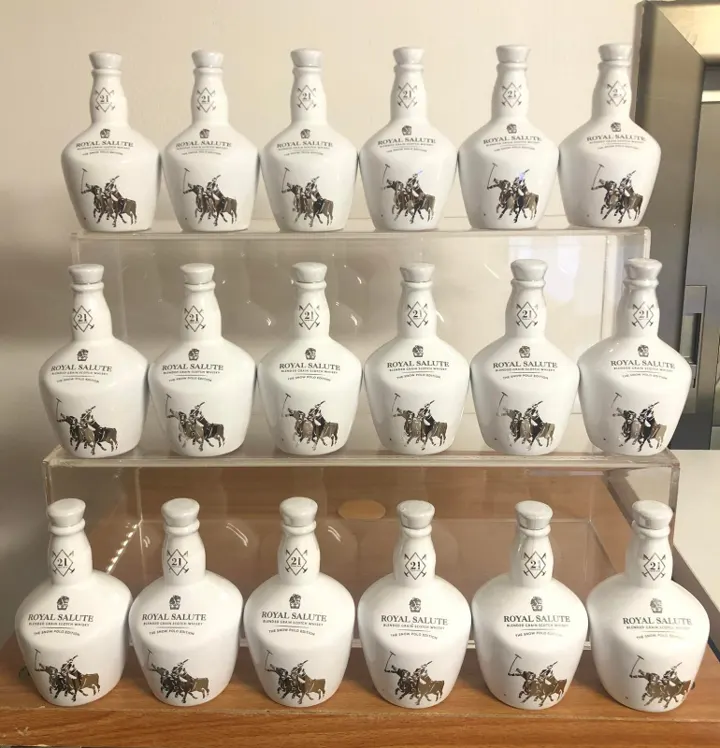 White Royal Salute Snow Polo Edition miniatures in rows on acrylic shelves