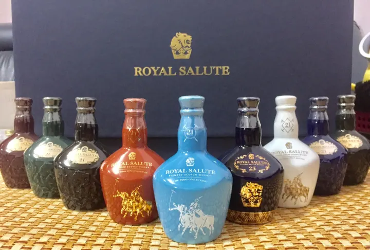 Row of Royal Salute miniature flagons in green, brown, red, light blue, dark blue, white and black